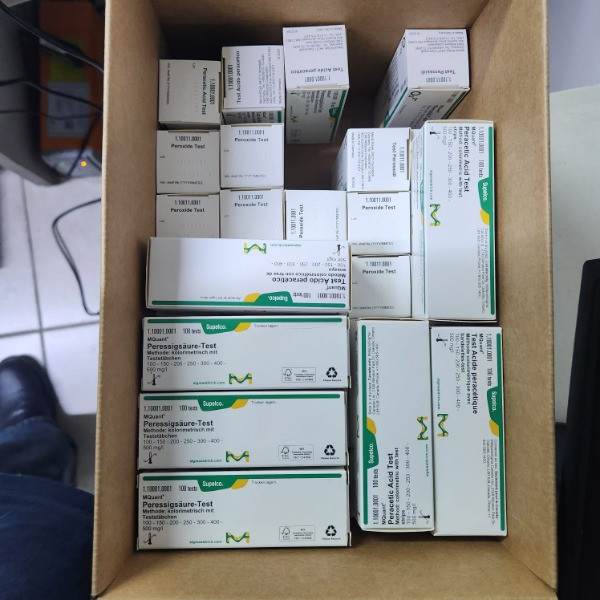 «چیدمان منظم چندین بسته تست پراکسید MQuant مرک آلمان کد 1.10011.0001 داخل یک کارتن، مناسب برای سنجش پراکسید در آزمایشگاه‌ها؛ نمایش واضح لیبل‌ها و بسته‌بندی اصلی محصول مرک.»